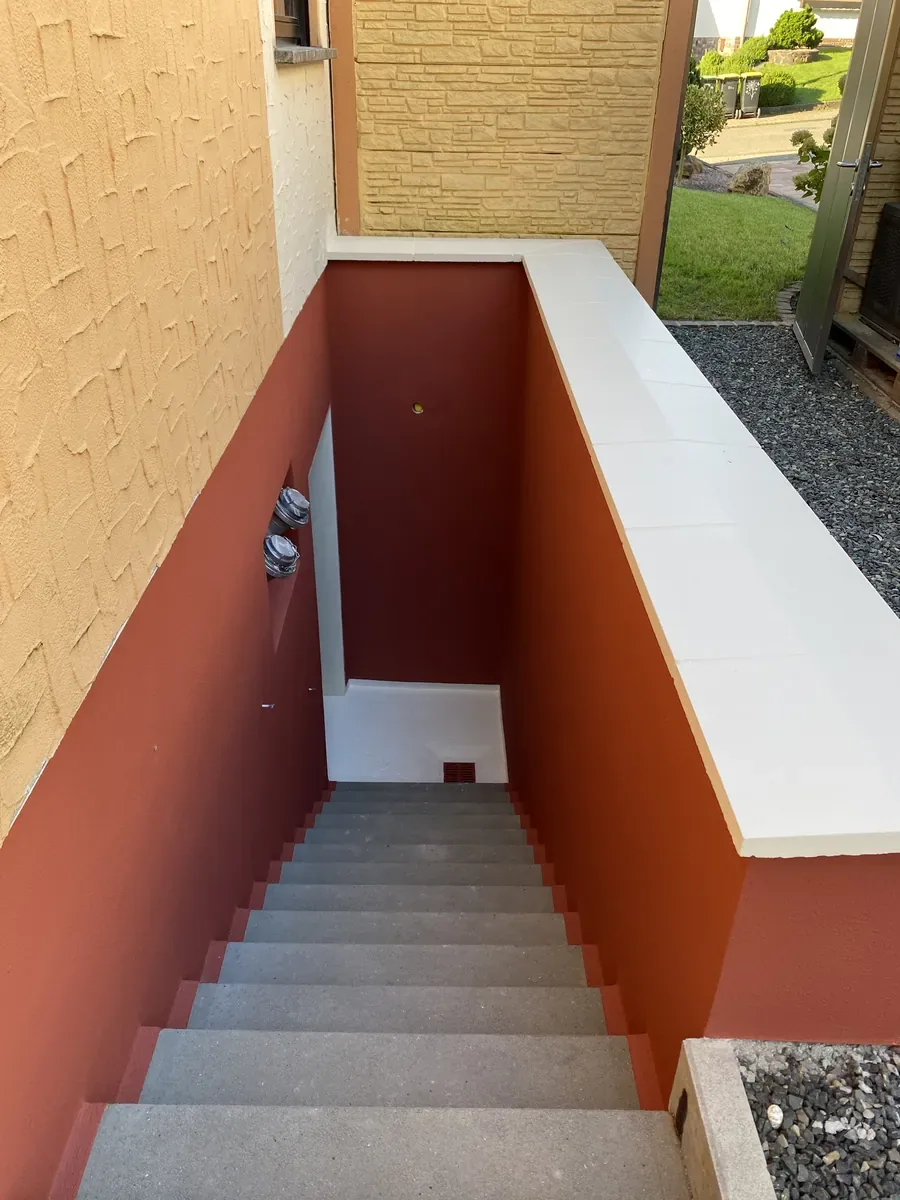 Kellerabgang in Hüttigweiler nach den Malerarbeiten: rot gestrichene Wände, helle Abdeckung, gereinigte Treppe